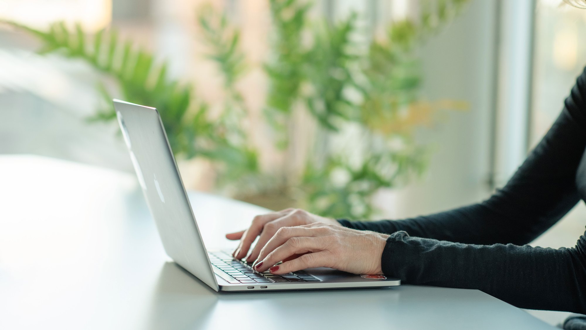 Hands typing on laptop